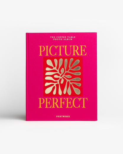 Picture Perfect dizaino fotoalbumas ant kavos staliuko, ryškus rožinis viršelis, moderni interjero detalė