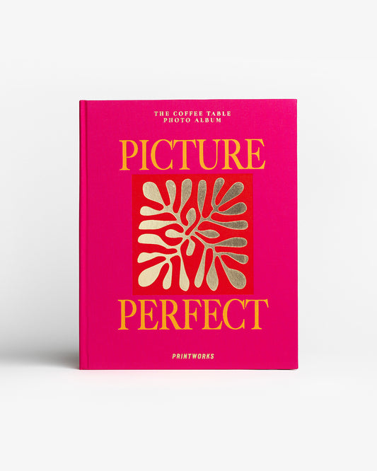 Picture Perfect dizaino fotoalbumas ant kavos staliuko, ryškus rožinis viršelis, moderni interjero detalė